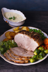 Roasted sliced ham, vegetables and sauce.