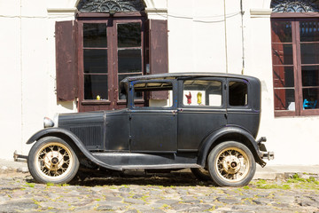Black and obsolete car on one of the cobblestone streets, in the city of Colonia del Sacramento, Uruguay. It is one of the oldest cities in Uruguay.