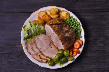 Roasted sliced ham and vegetables. View from above, top studio shot