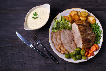 Roasted sliced ham, vegetables and sauce. View from above, top studio shot
