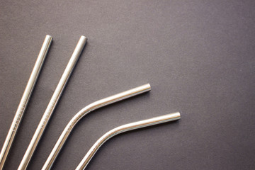 Metal straws on black background. Zero waste. Flat lay 