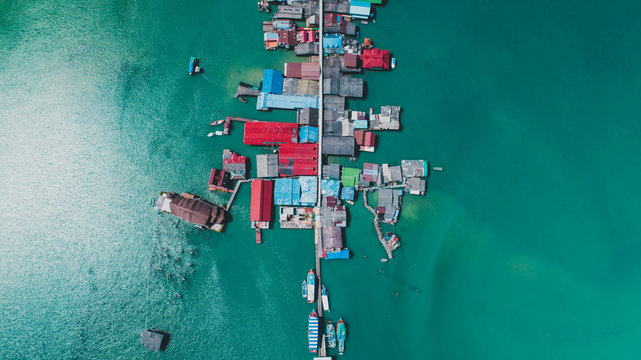 Boats docked beside buildings above water during day