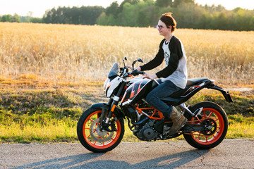 Fototapeta premium young boy driving motorycle without a helmit on a country road in the summer