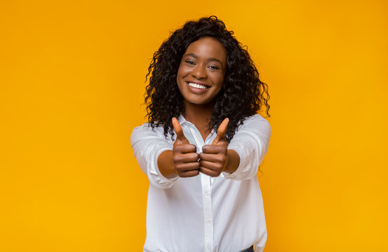 Happy young black woman showing thumbs up