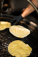 Close up of cooking cakes on big grill surface outdoor