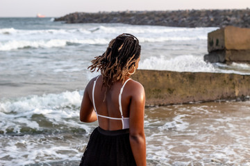 Fototapeta na wymiar Young African Lady walking by the beach