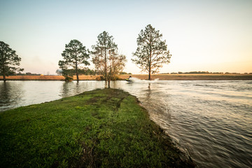 Teenage boy man driving a personal watercraft outside on a lake pond at sunset