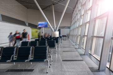 There are empty chairs, benches for passengers waiting for flights at the airport terminal, selected focus