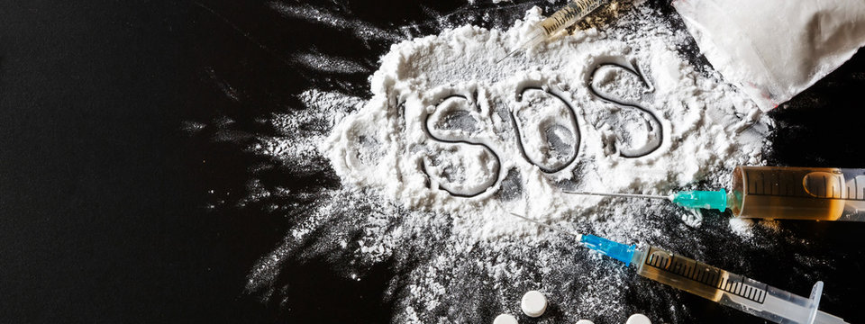 drug is a white powder, tablets, syringes sprinkled on a black table. Dangerous illegal business. Flat Lay Addiction Concept long banner