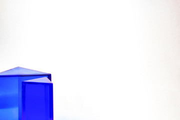 Two blue triangular prisms in the lower left corner on a white background