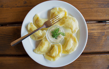 Dumplings on a white plate with sour cream. - Traditional Ukrainian food.