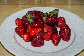 A plate of beautiful strawberries isolated on white background, close up, macro.