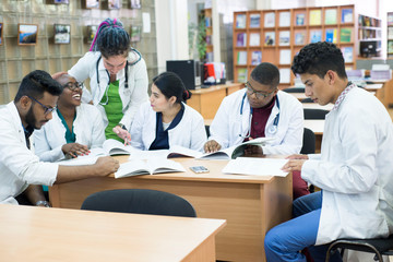 young doctors A group of people of mixed race, sitting at the table, talking, discussing health problems.
