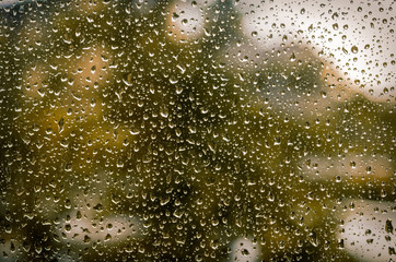 Drops of rain on the window glass on a blurred background. Selective focus.