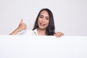 Young Asian woman show thumbs up with blank sign.