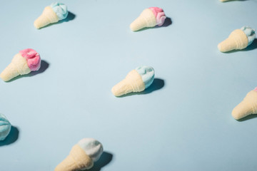 Trendy sunlight Summer pattern made with pink strawberry ice cream on bright light blue background. Minimal summer concept.