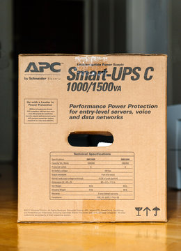 PARIS, FRANCE - MAR 29, 2018: APC Smart-UPS C 1000VA LCD 230V enterprise-level uninterruptible power supplies made by American Power Conversion on office wooden floor