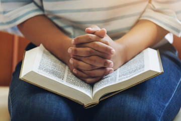 A Girl hand praying with holy bible