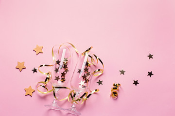 Christmas card with champagne glasses with confetti and streamers in pink and gold colors