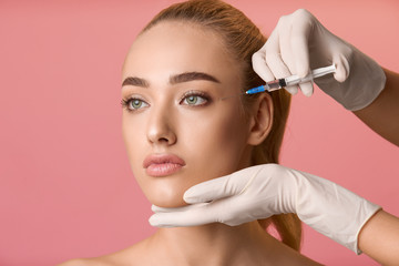 Young woman getting beauty injection near eyes