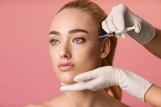 Young woman getting beauty injection near eyes