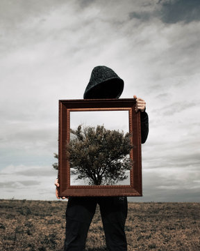 Man holding brown wooden frame