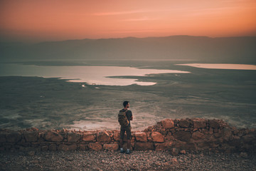 man standing facing sea