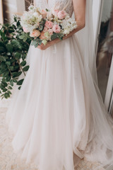 Plakat the bride in a white dress holding a bouquet of flowers
