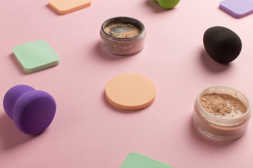 Sponges, beauty blender for applying foundation or powder. Flat lay on a pink background, copy space.
