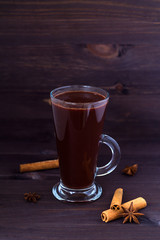 cup of hot chocolate with cinnamon and anise on wooden background