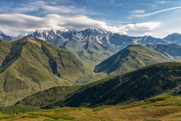 Obraz premium view of main Caucasian ridge from Svanet ridge, panorama of Caucasus, view of mountains and mountain valley, village in mountains, Ushguli, Caucasus, Georgia