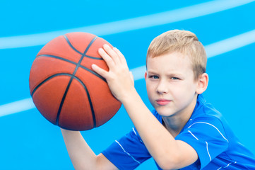 Adorable child playing the basketball in the basket field