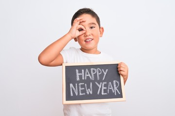 Beautiful kid boy holding blackboard standing over isolated white background with happy face smiling doing ok sign with hand on eye looking through fingers