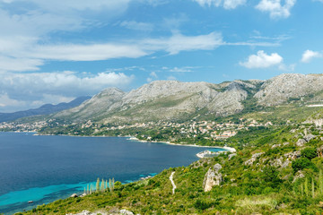 Naklejka na ściany i meble Views of the Adriatic Sea - clear blue water, boat, rocky shore. Sea cruise in a paradise