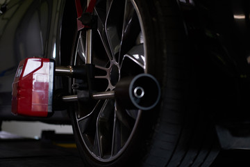 Closeup photoshoot of process or tyre balancing at dark auto service.