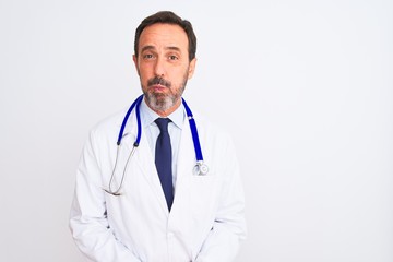 Fototapeta premium Middle age doctor man wearing coat and stethoscope standing over isolated white background puffing cheeks with funny face. Mouth inflated with air, crazy expression.