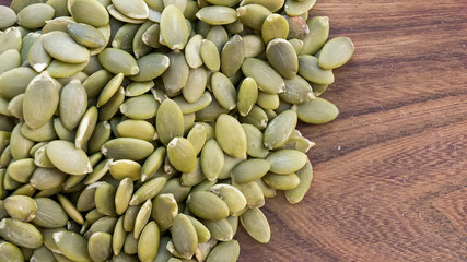 Green pumpkin seeds on wooden white background. Copy space