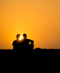 Naklejka na ściany i meble silhouette of couple on the beach at sunset