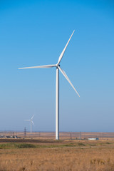 Huge wind generators against blue sky, close up.	Spinning wind turbines on blue sky background, close up	