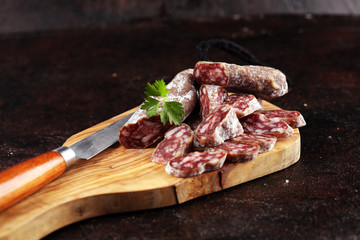 salami cut. thinly sliced salami on a wooden texture on the background.