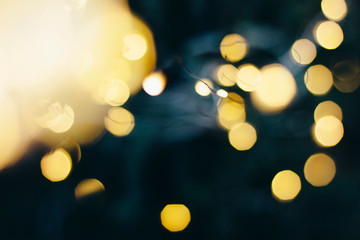 Fototapeta premium A beautiful image of a bokeh from New Year's garlands. In gold colors. Defocused glitter lighting image for art and design.