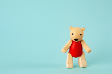 Wooden bear toy with green background. Horizontal image