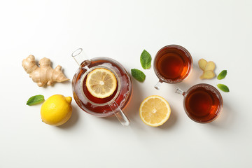 Flat lay. Cups with tea and teapot, lemon, mint and ginger, space for text