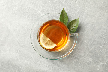 Cup of tea, mint and lemon on grey background, top view