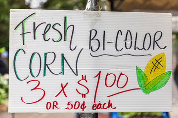 USA, Washington State, Vancouver. Vendor's sign for fresh corn on the cob at a farmers market.