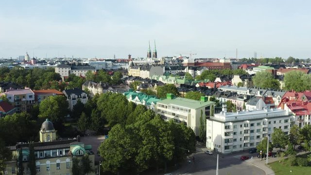 Aerial, rising, drone shot, over the Eira cityscape, overlooking streets, buildings and the st john church, on a sunny, summer day, in Helsinki, Uusimaa, Finland
