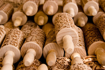 Many wooden rolling pins with beautiful ornaments for decorating biscuits