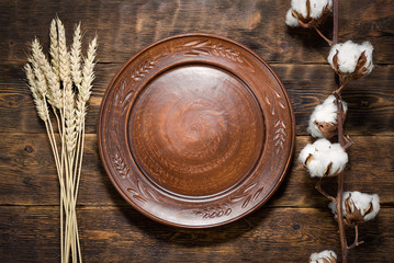 Empty plate with a copy space for food on a brown wooden kicthen table background.