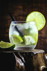 Fresh summer alcoholic caipirinha on a rustic wooden table, party drinks cocktail background. Space for text. Brazilian summer cold drink.