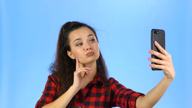 Lady making selfie and with duckface on her phone